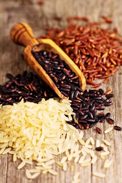 عکس انواع مختلف برنج بر روی پس زمینه چوبی با جزئیات زیبا