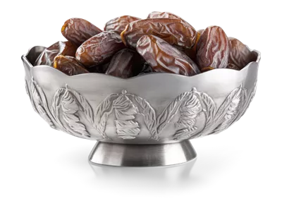 عکس دوربری تصویری زیبا از میوه های خرما در یک کاسه نقره ای با طراحی هنری