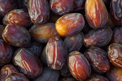 عکس تصویری نزدیک از خوشه ای از خرماهای تازه و خوشمزه