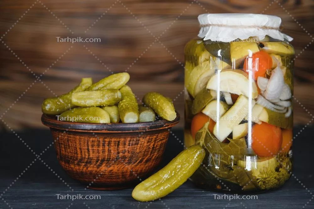 عکس ترکیب خیارشور و خیار تازه در کاسه ای چوبی بر روی میز روستایی
