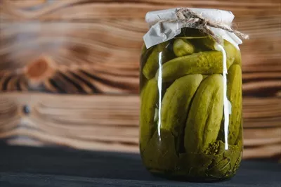 عکس ترکیبات و مراحل تهیه خیارشور خانگی در شیشه های شفاف