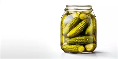 عکس خیار شور در شیشه شفاف با پس زمینه سفید و فضای خالی