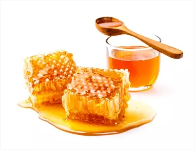 عکس عسل طبیعی درون شیشه و قاشق عسل بر روی پس زمینه سفید