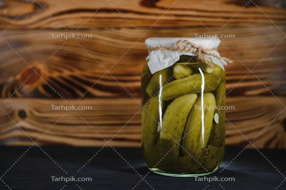 عکس ترکیب خیارشور و خیار تازه در کاسه ای چوبی بر روی میز روستایی