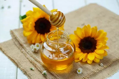 عکس زیبای یک شیشه عسل با قاشق و عسل در حال ریختن بر روی بوم