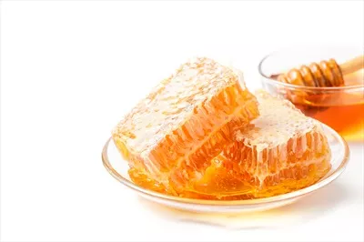 عکس عسل تازه و موم عسل در پس زمینه سفید: طعمی طبیعی و دلپذیر