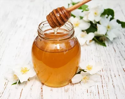 عکس عسل معطر با گل های یاس بر روی پس زمینه چوبی زیبا و دلنشین
