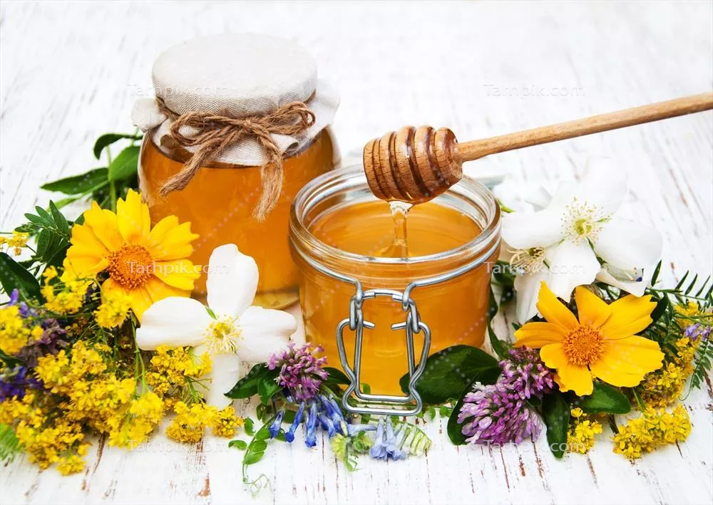 عکس عسل و گل های وحشی بر روی پس زمینه چوبی زیبا و دلنشین