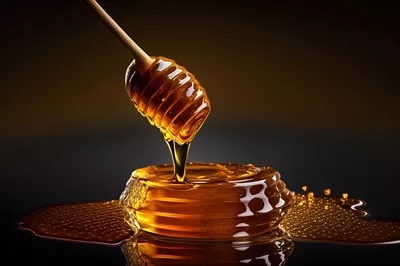عکس تصویری زیبا از قاشق عسل با عسل در حال چکیدن برای زنبورداران