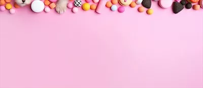 عکس پس زمینه ای صورتی با انبوهی از آب نبات ها و شیرینی ها به سبک هوش مصنوعی