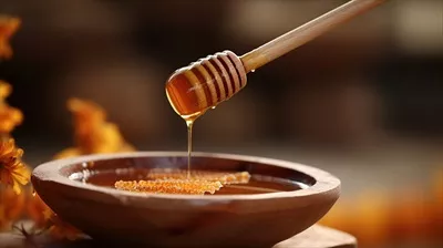 عکس عسل طبیعی و غلیظ در کاسه چوبی با قاشق چوبی و گل های زیبا