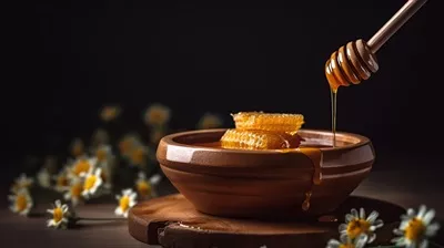 عکس عسل طبیعی و غلیظ در حال چکیدن از قاشق چوبی در کاسه چوبی