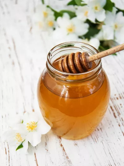 عکس عسل معطر با گل های یاس بر روی پس زمینه چوبی زیبا و دلنشین