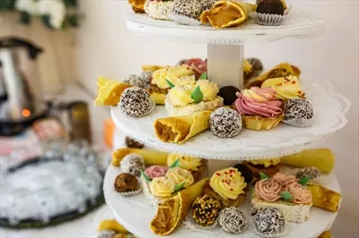 عکس نمایی زیبا از میز دسرهای جشن عروسی با تنوعی از شیرینی ها و تزئینات خاص