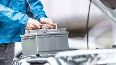 عکس تعویض باتری خودرو توسط مکانیک در کارگاه تعمیرات خودرو
