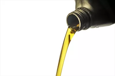 عکس جریان روانکار از بطری خاکستری بر روی پس زمینه سفید
