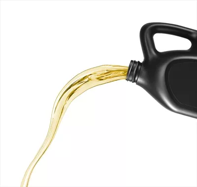 عکس ریختن روغن موتور از قوطی در پس زمینه سفید