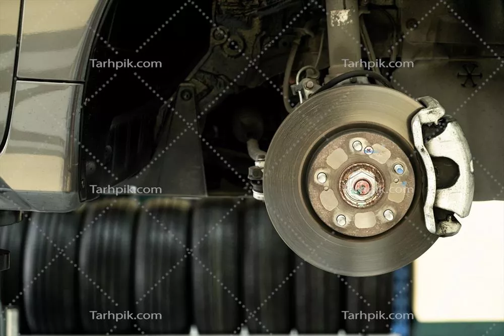 عکس نزدیک شدن به جزئیات فنی خودرو: مکانیک در حال باز کردن قطعات اتومبیل
