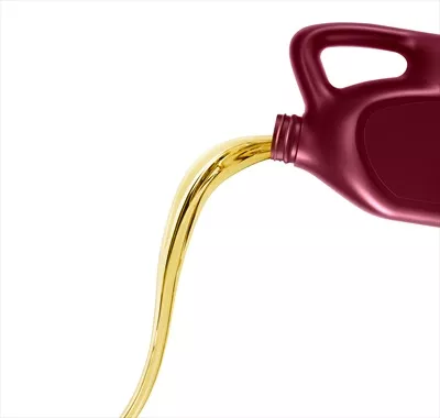 عکس ریختن روغن موتور از قوطی در پس زمینه سفید