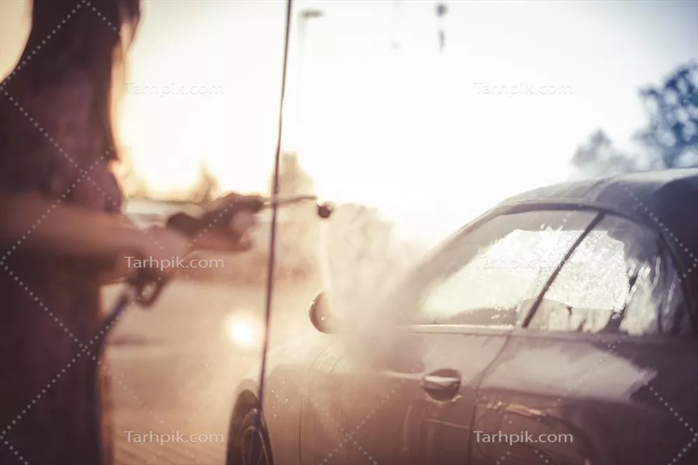 عکس زنی که در غروب آفتاب خودروی خود را شستشو می دهد