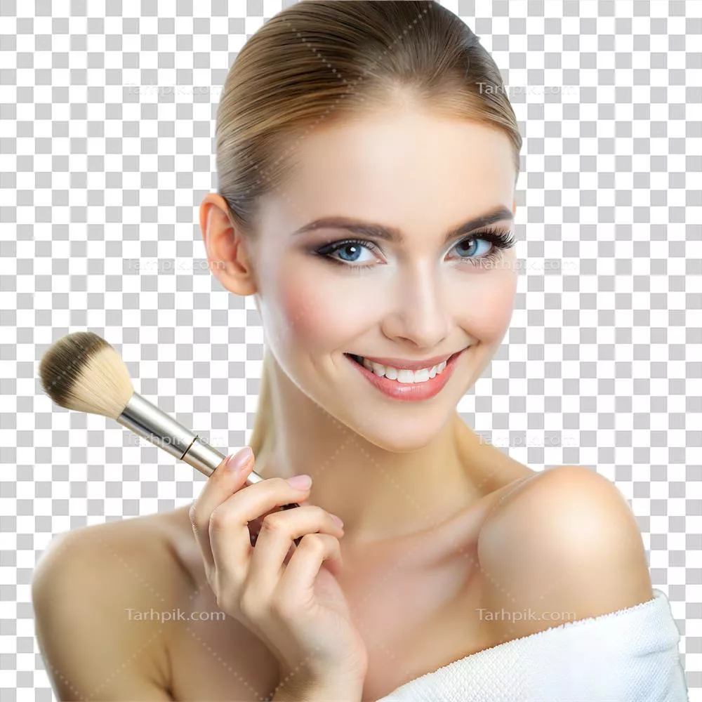 عکس دوربری زنی شاداب با چشمان آبی که قلم موی آرایشی را نزدیک صورتش نگه داشته است
