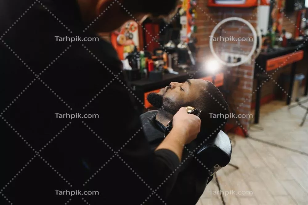 عکس بازدید از یک آرایشگاه مدرن با مردی آفریقایی-آمریکایی در حال اصلاح مو