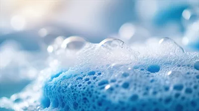 عکس تصویری زیبا از حباب های کف صابون و اسفنج آبی در یک محیط آرام