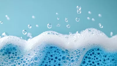 عکس تصویری زیبا از حباب های کف صابون و اسفنج آبی در یک محیط آرام