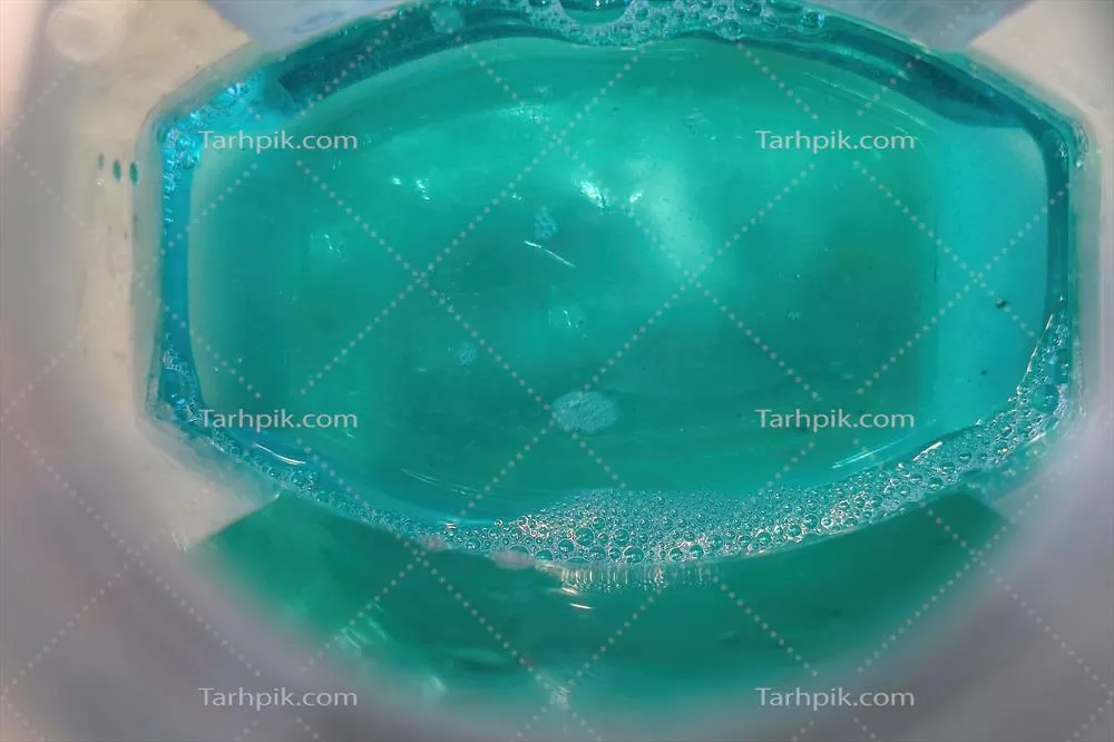 عکس محلول دهانشویه سبز رنگ درون بطری شفاف و جذاب
