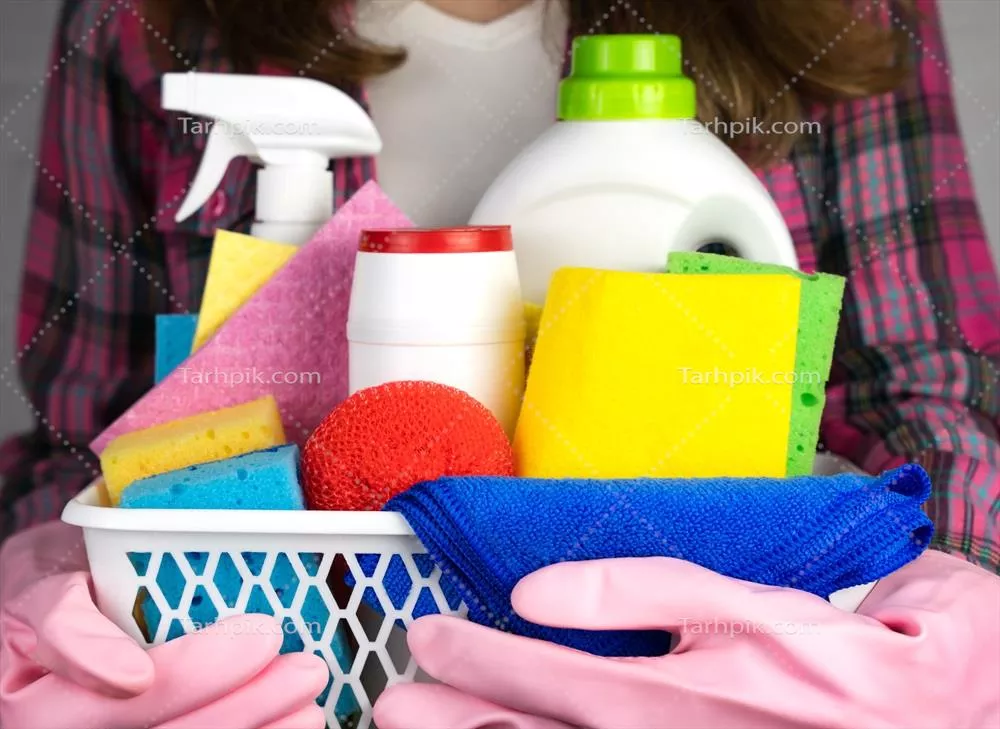 عکس زنی با دستکش لاستیکی در حال نگهداری مواد شوینده برای نظافت منزل