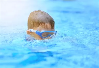 عکس کودکی با عینک غواصی در حال شیرجه زدن به عمق دریا