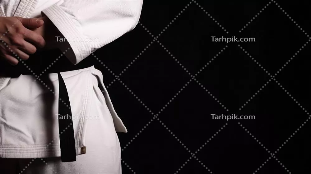عکس مردی در لباس کاراته با کمربند سیاه، نماد تسلط و مهارت در هنرهای رزمی