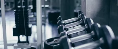 عکس تصویری زیبا از ردیف دمبل ها در یک باشگاه ورزشی مدرن
