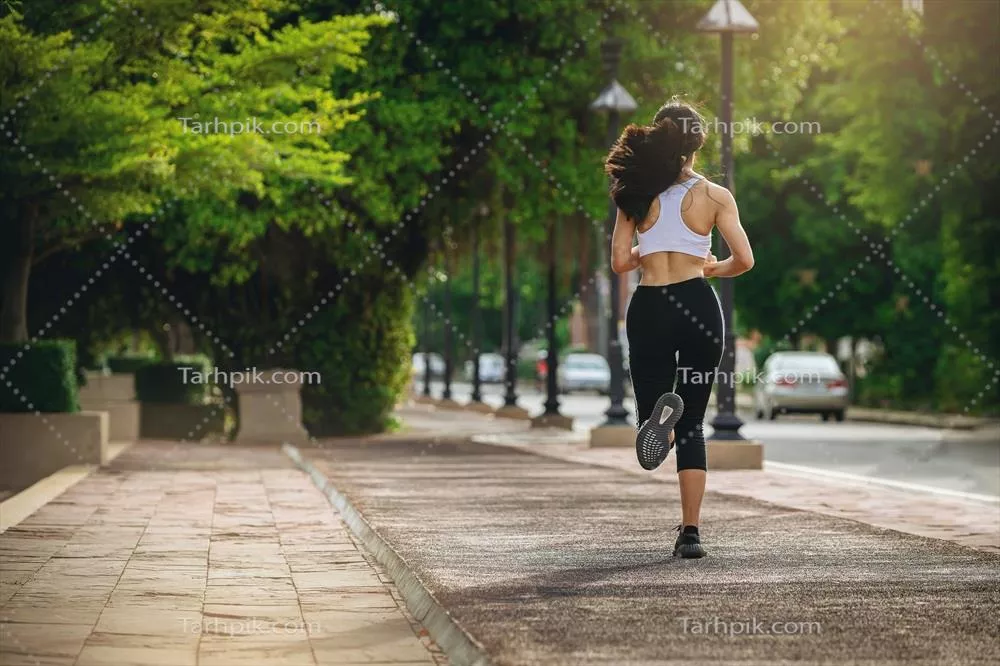 عکس تصویری زیبا از یک زن جوان در حال دویدن در غروب آفتاب
