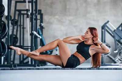عکس دختر جوان و ورزشکار در لباس ورزشی مشکی در حال انجام حرکات یوگا