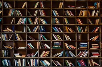 عکس کتابخانه ای با قفسه های پر از کتاب های قدیمی و محو شده