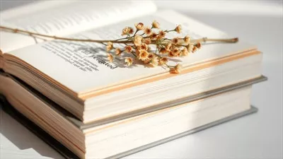 عکس گل های خشک شده بر روی کتاب باز: زیبایی طبیعت در صفحات ادبیات