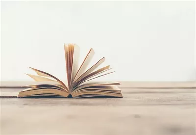 عکس کتاب های قدیمی و نوستالژیک بر روی میز چوبی با طراحی زیبا