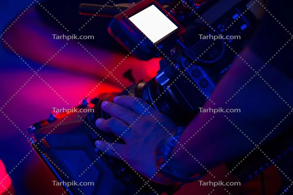 عکس تصویری نزدیک از یک فیلمبردار با دوربین در حال ضبط در یک مکان زیبا