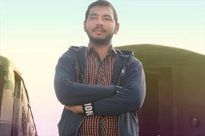 عکس پرتره ای از یک مرد جوان آسیایی با اعتماد به نفس در برابر قطار