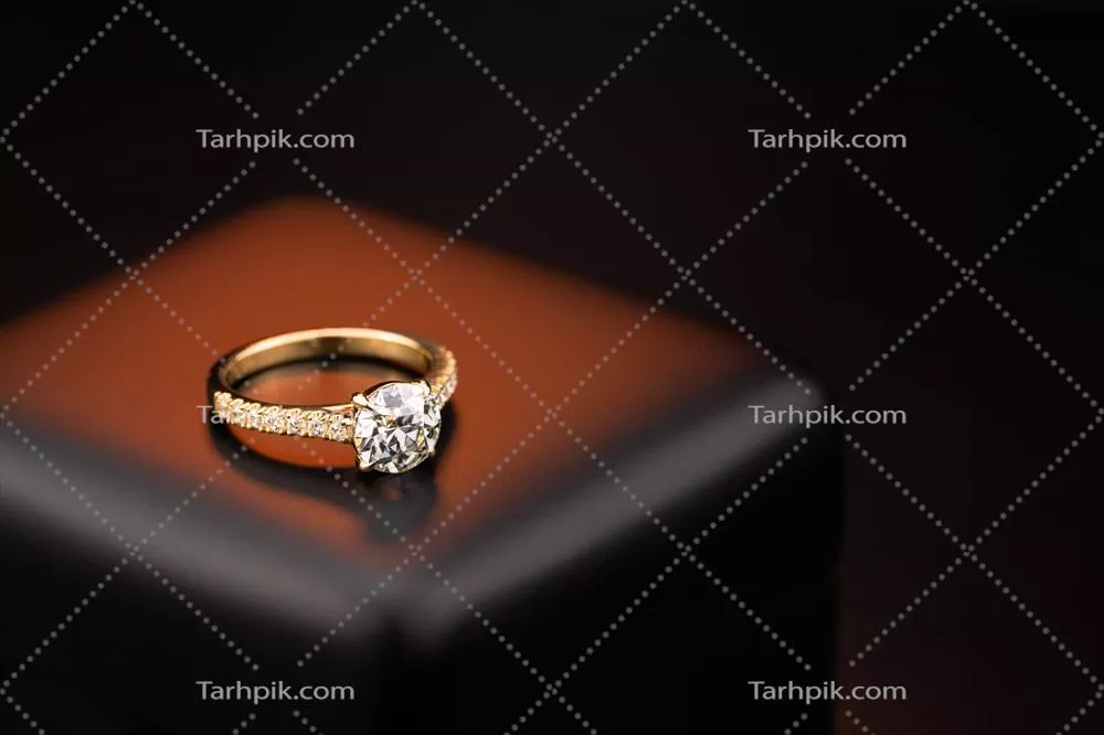 عکس حلقه ازدواج طلایی و الماس بر روی جعبه جواهرات با طراحی زیبا