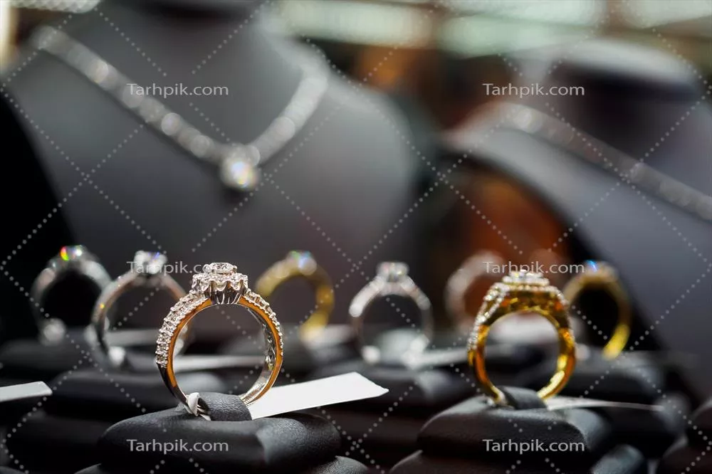 عکس نمایشگاه لوکس جواهرات شامل حلقه ها و گردنبندهای الماس در ویترین فروشگاه