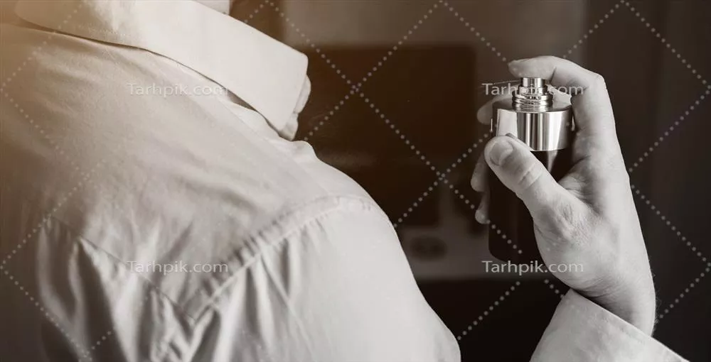 عکس مردی با ظاهری شیک و جذاب در حال استفاده از عطر با رایحه دلپذیر