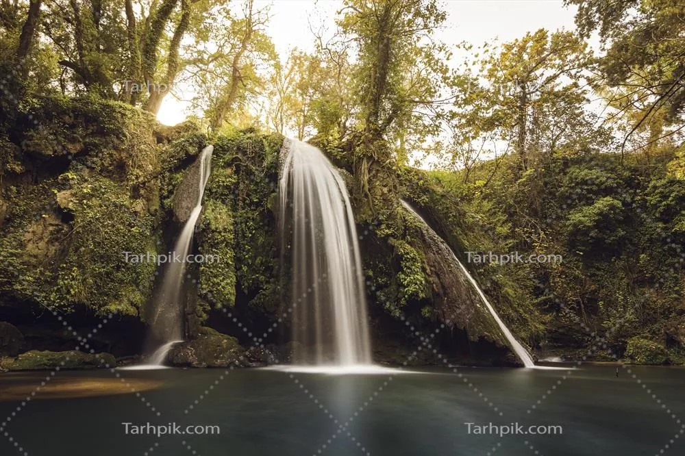 عکس منظره ای زیبا از آبشار در پرووانس فرانسه در نور گرم غروب پاییزی