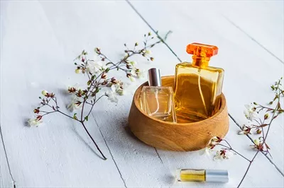عکس مجموعه ای زیبا از بطری های عطر در یک کاسه چوبی جذاب
