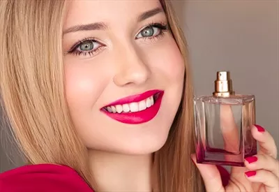 عکس پرتره زن زیبا با عطر و لوازم آرایشی در فضایی لوکس و شیک