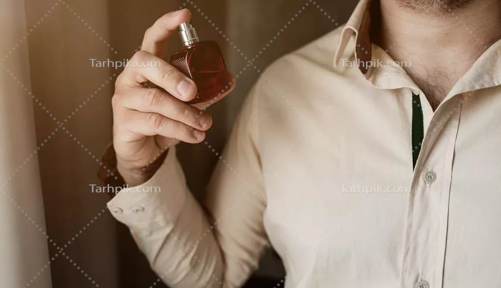 عکس مردی در حال استفاده از عطر با پیراهن شیک و جذاب