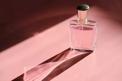 عکس عطر زیبا در نور مستقیم با سایه های رنگی بلند و جذاب