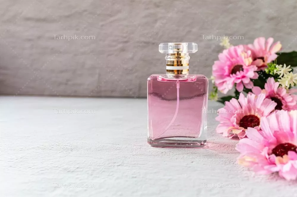عکس بطری عطر صورتی زیبا با گل های صورتی در پس زمینه