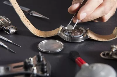عکس تعمیرکار ساعت: تعویض باتری ساعت با دقت و مهارت بالا